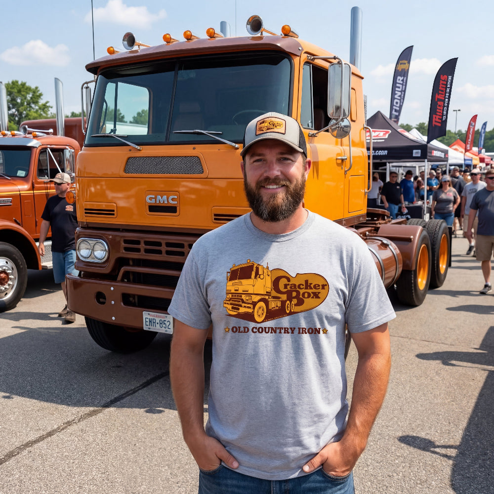 Man standing in front of a GMC Cracker Box truck at a truck show.