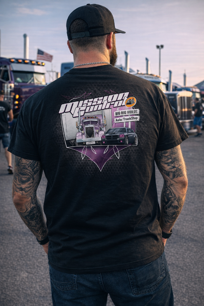 Person wearing a Dodge Magnum SRT8 Mission Control tshirt standing in an outdoor setting with trucks in the background.